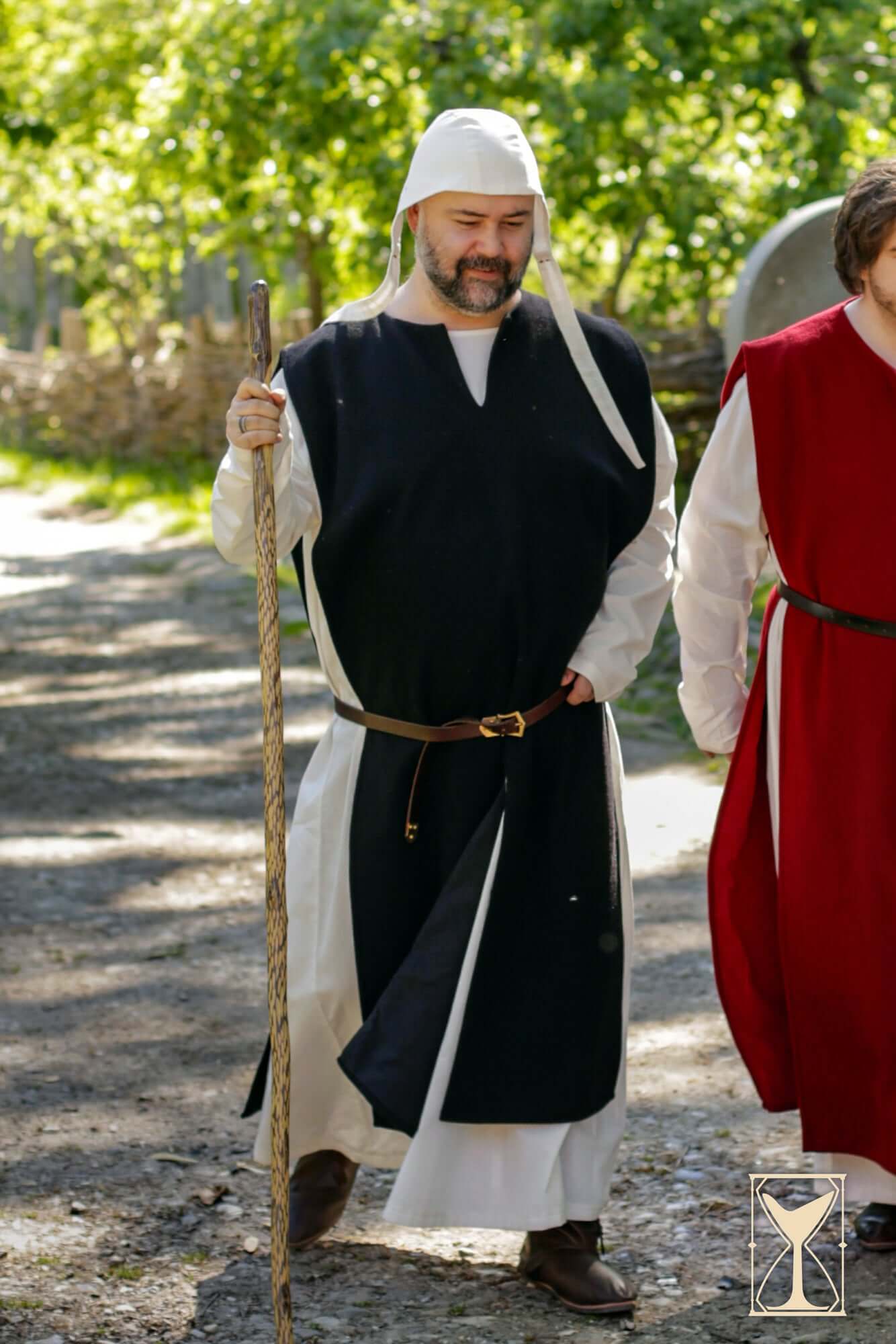 Cyclas Bernard worn by a man with a staff, showcasing medieval style and grounded realism in a historical setting.