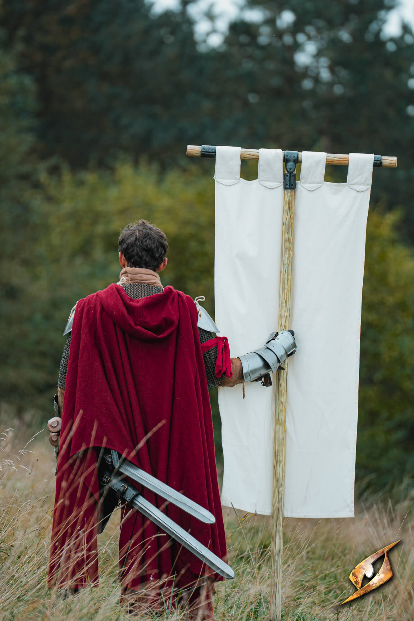 Person holding a Complete Battle Standard Set - T-Top in a field, dressed in a red cloak with swords.