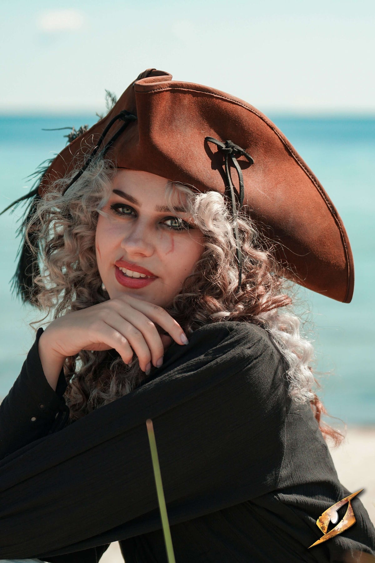A model wearing a Simple Leather Pirate Tricorn Hat by the sea, showcasing its distinctive three-cornered design.