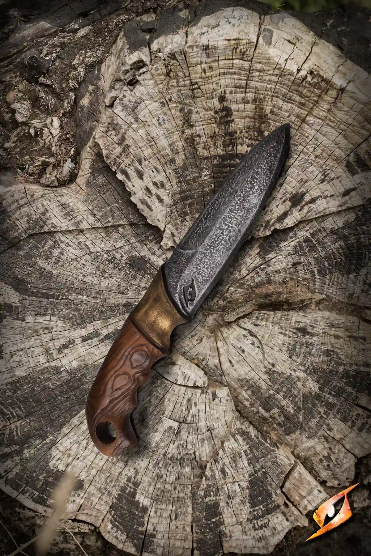 Woodsman Knife - 23 cm displayed on a tree stump, showcasing its sharp blade and ergonomic handle.