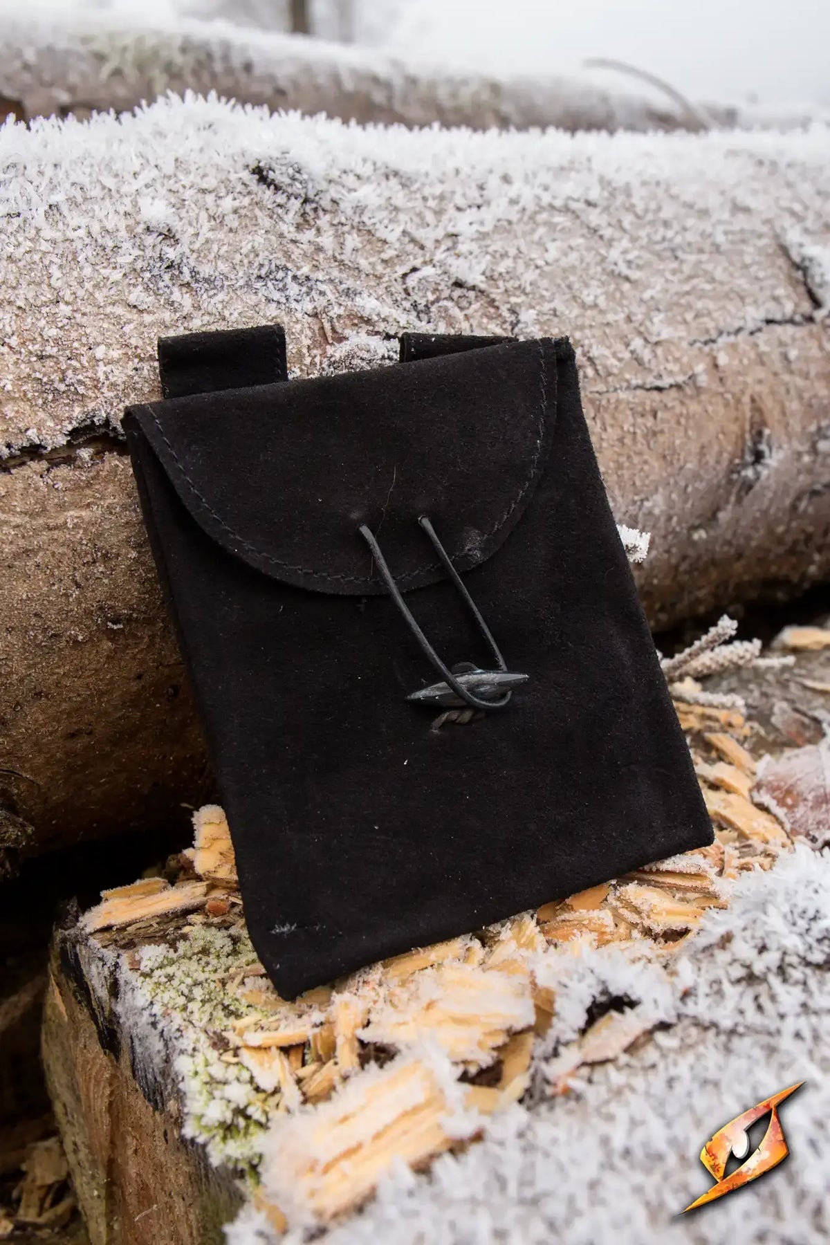Leatherbag Thin - Small in Epic Black, a slim leather bag resting on frozen logs.