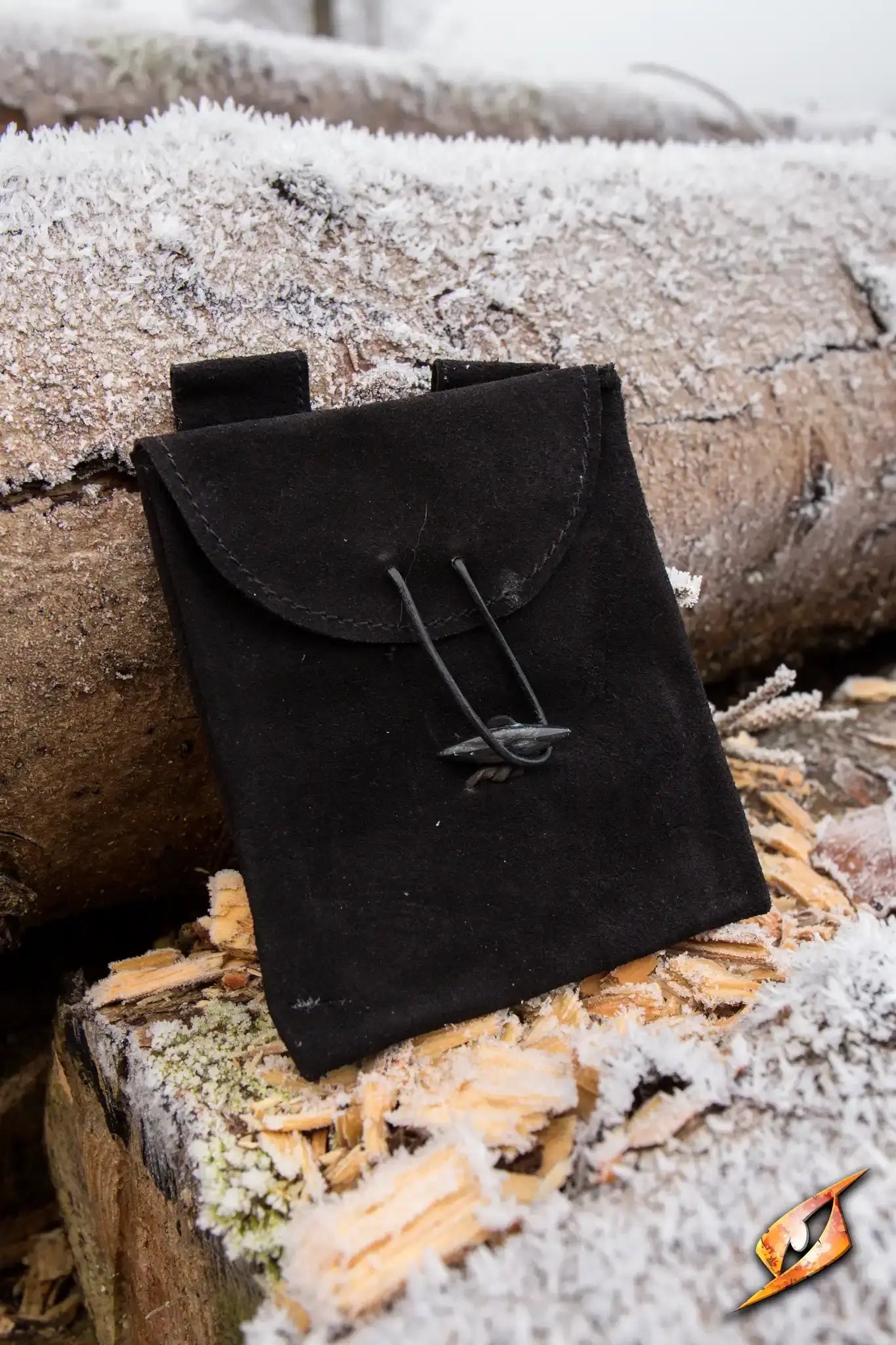Leatherbag Thin - Small in Epic Black, a slim leather bag resting on frozen logs.