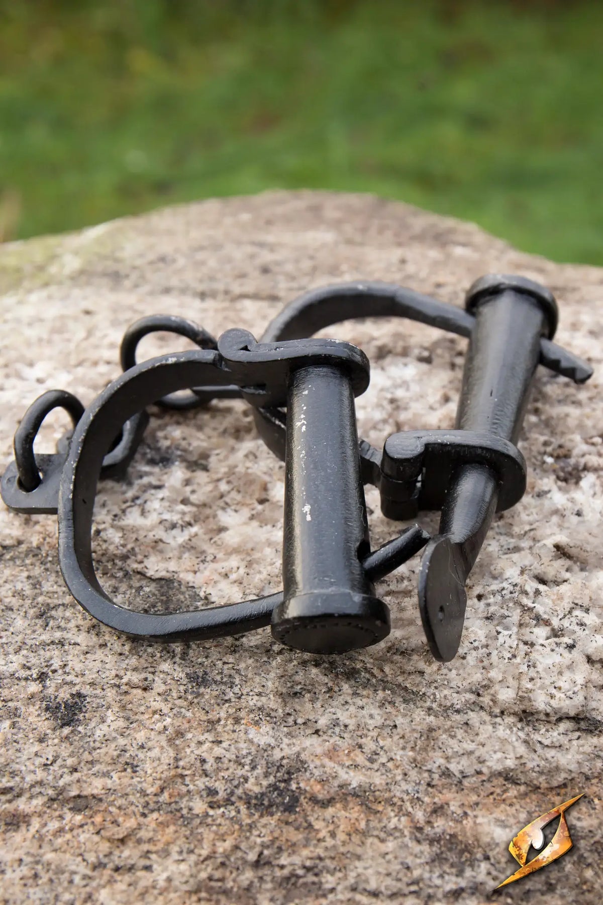 Handcuffs resting on a rock surface, ideal for law enforcement and personal security.