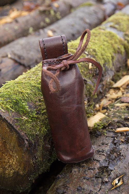 Telescope With Leather Pouch - Brass resting on mossy logs in a natural setting.