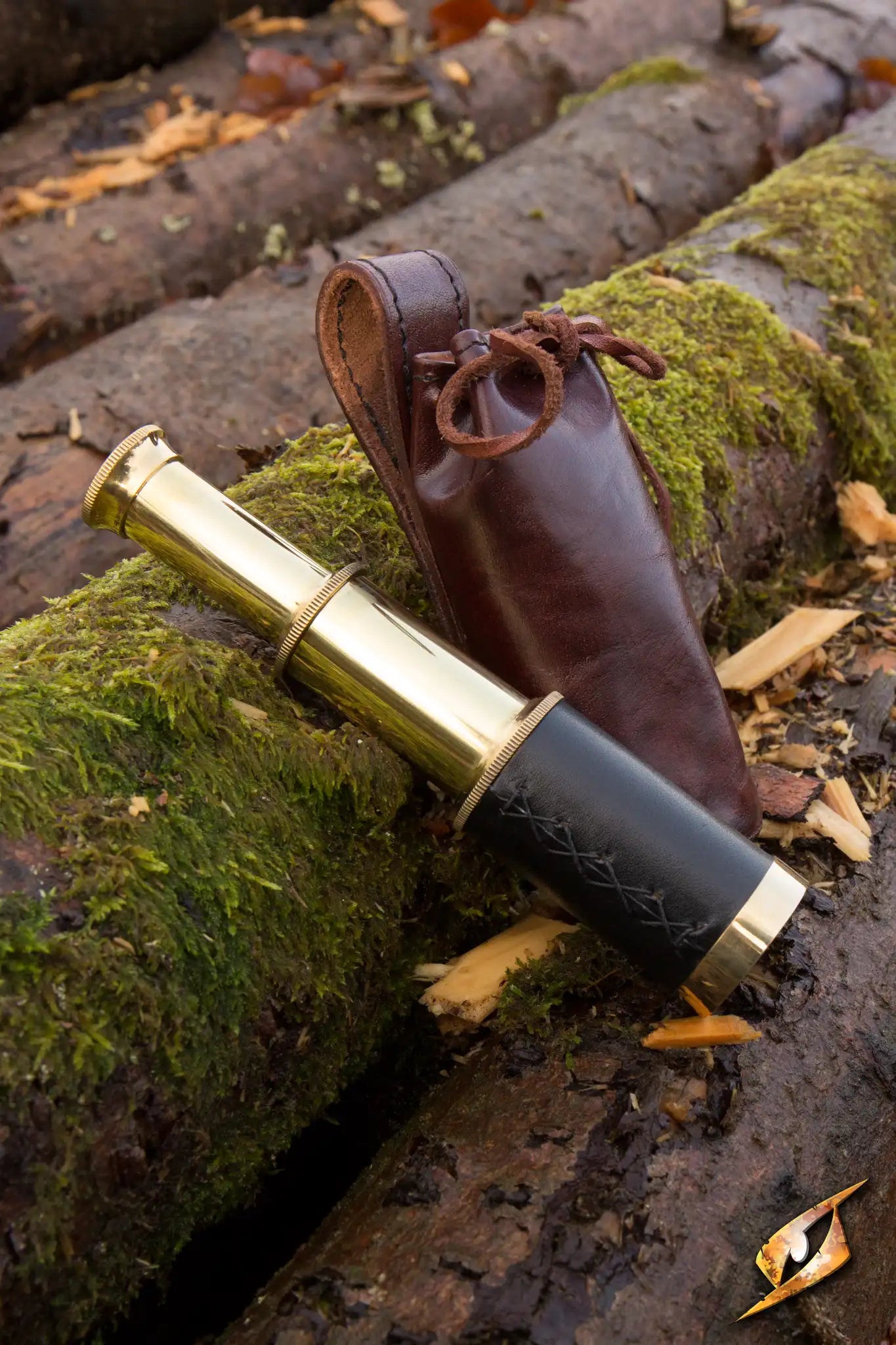 Telescope With Leather Pouch - Brass placed on mossy logs in an outdoor setting.