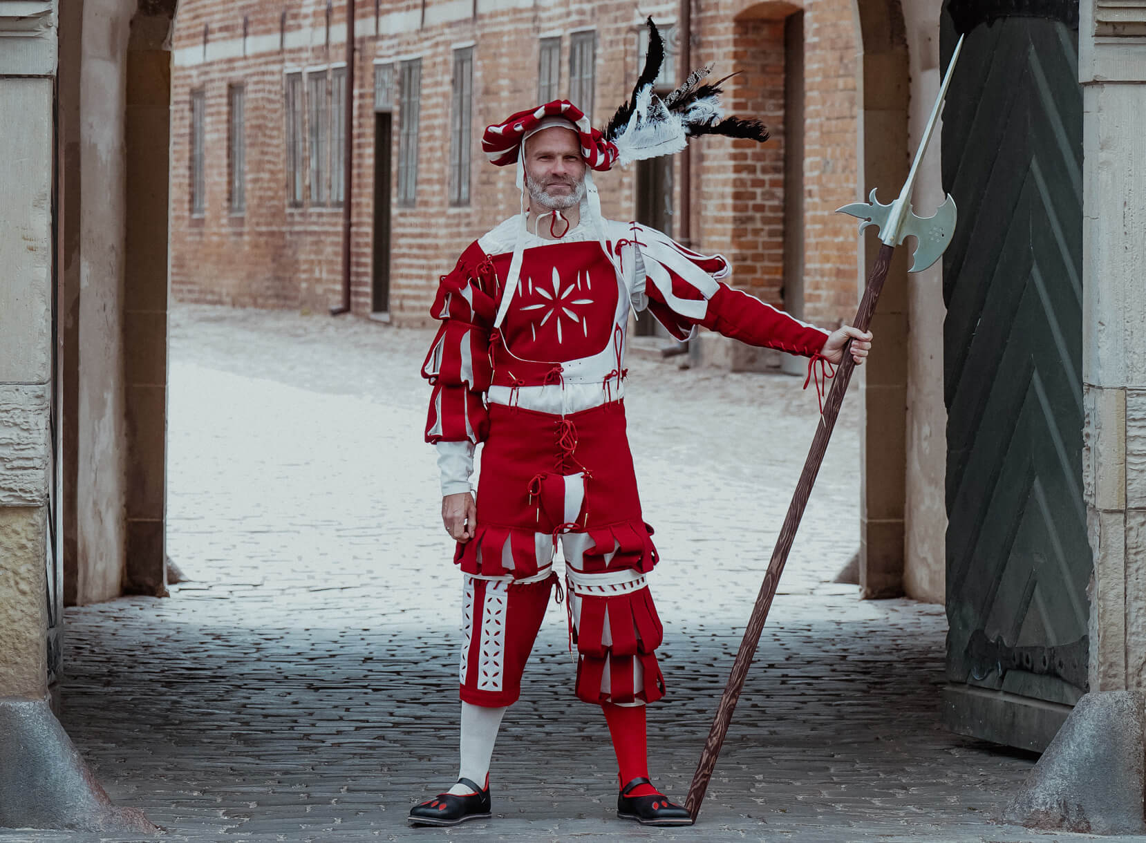 Man in Landsknecht outfit with halberd, Renaissance historical costume.