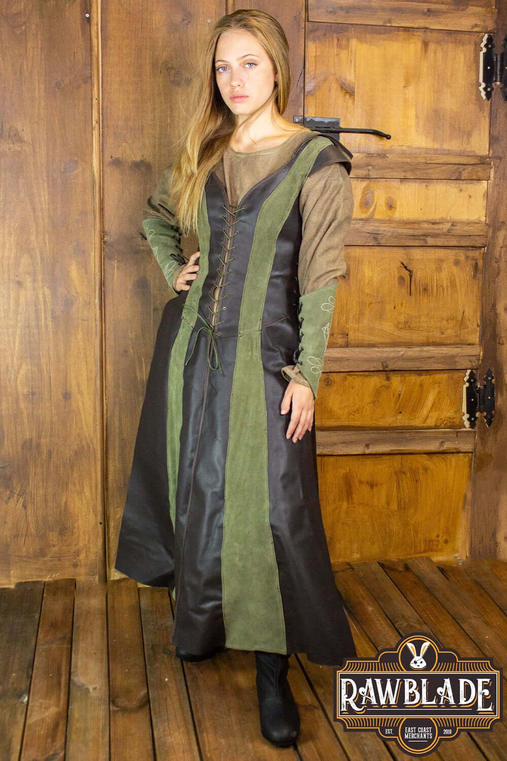 A woman models the Arylith Archer Leather Tunic by Rawblade, showcasing its fitted design and elegant hood.
