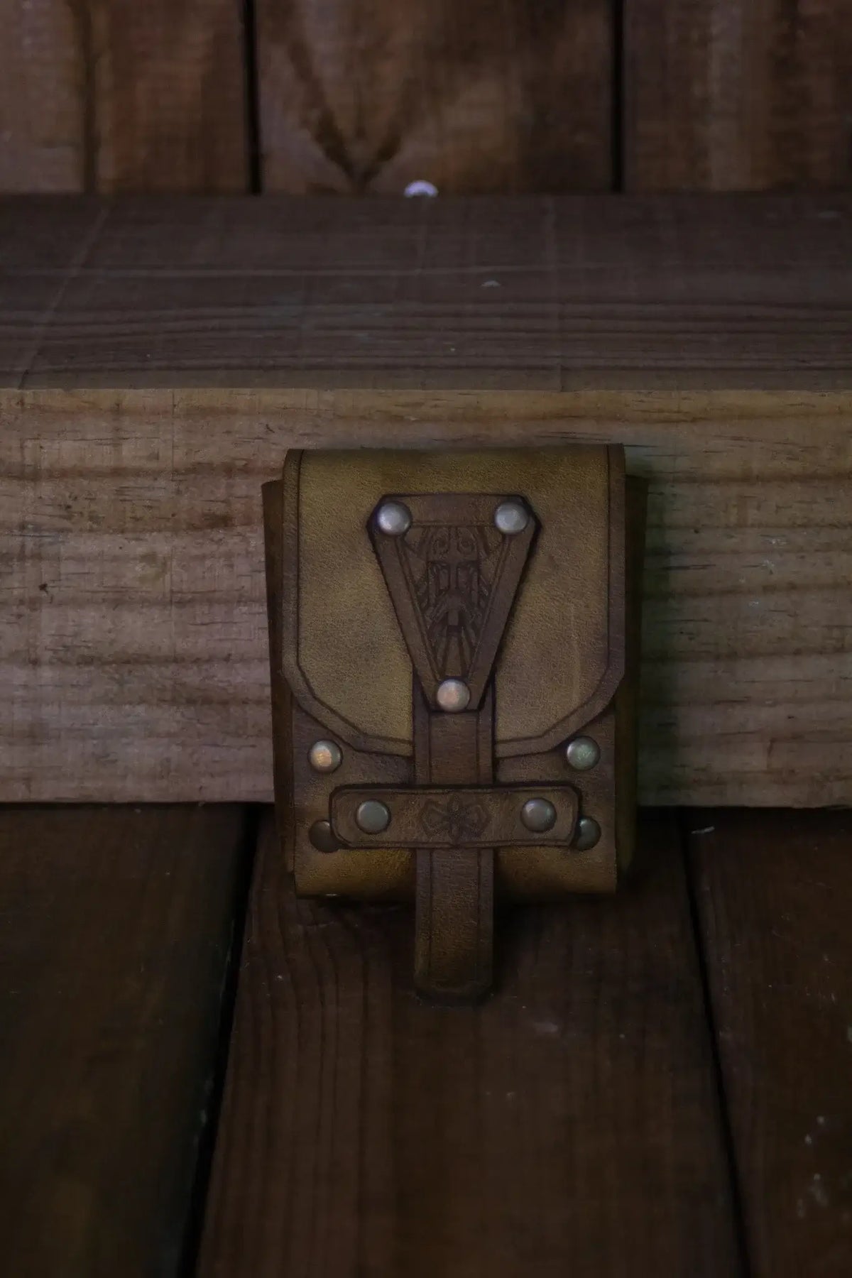 Bormund Pouch Small resting on wooden surface, showcasing unique dwarven design and leather craftsmanship.