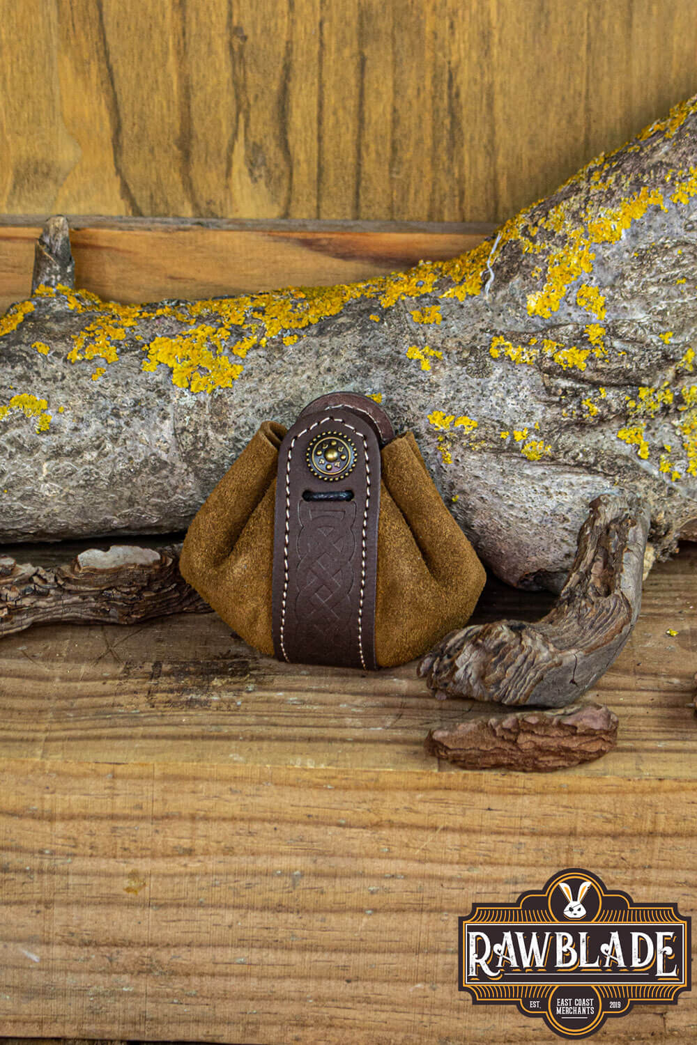 Wanderer Pouch Small in brown split-leather with Celtic motifs on a rustic wooden background.