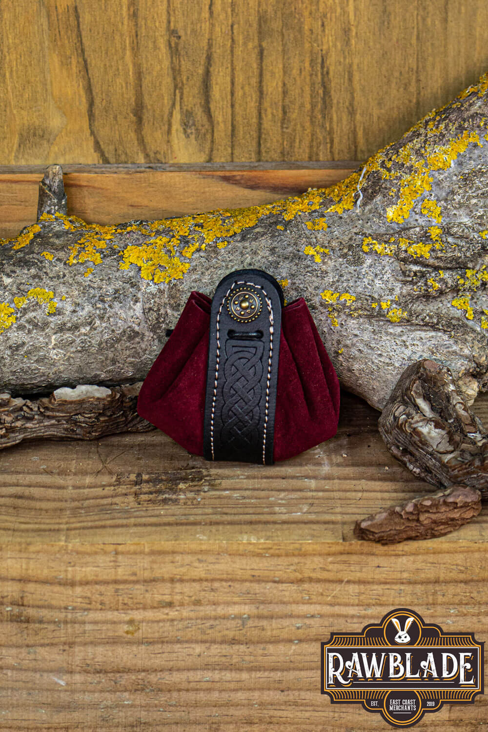 Wanderer Pouch Small in red split-leather with Celtic motifs and metal trimmings on wood background.