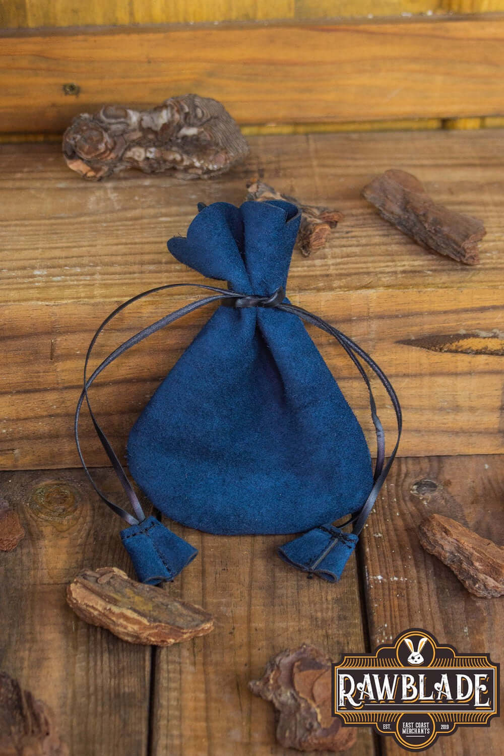 Alentorn Coin Bag made of soft split leather with leather drawstrings on a wooden surface.