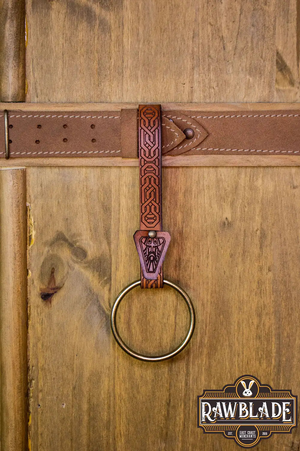 Bormund Ring Holder featuring ornate engraving and gold rivets on a leather belt, crafted by Spanish artisans.