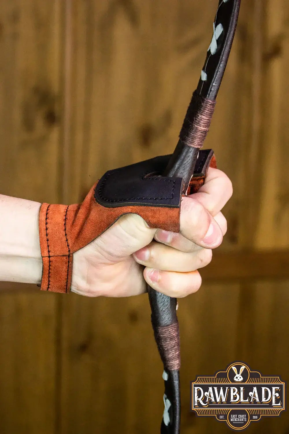Archery Glove Oren worn while gripping a bow, showcasing high-quality leather and adjustable fit.