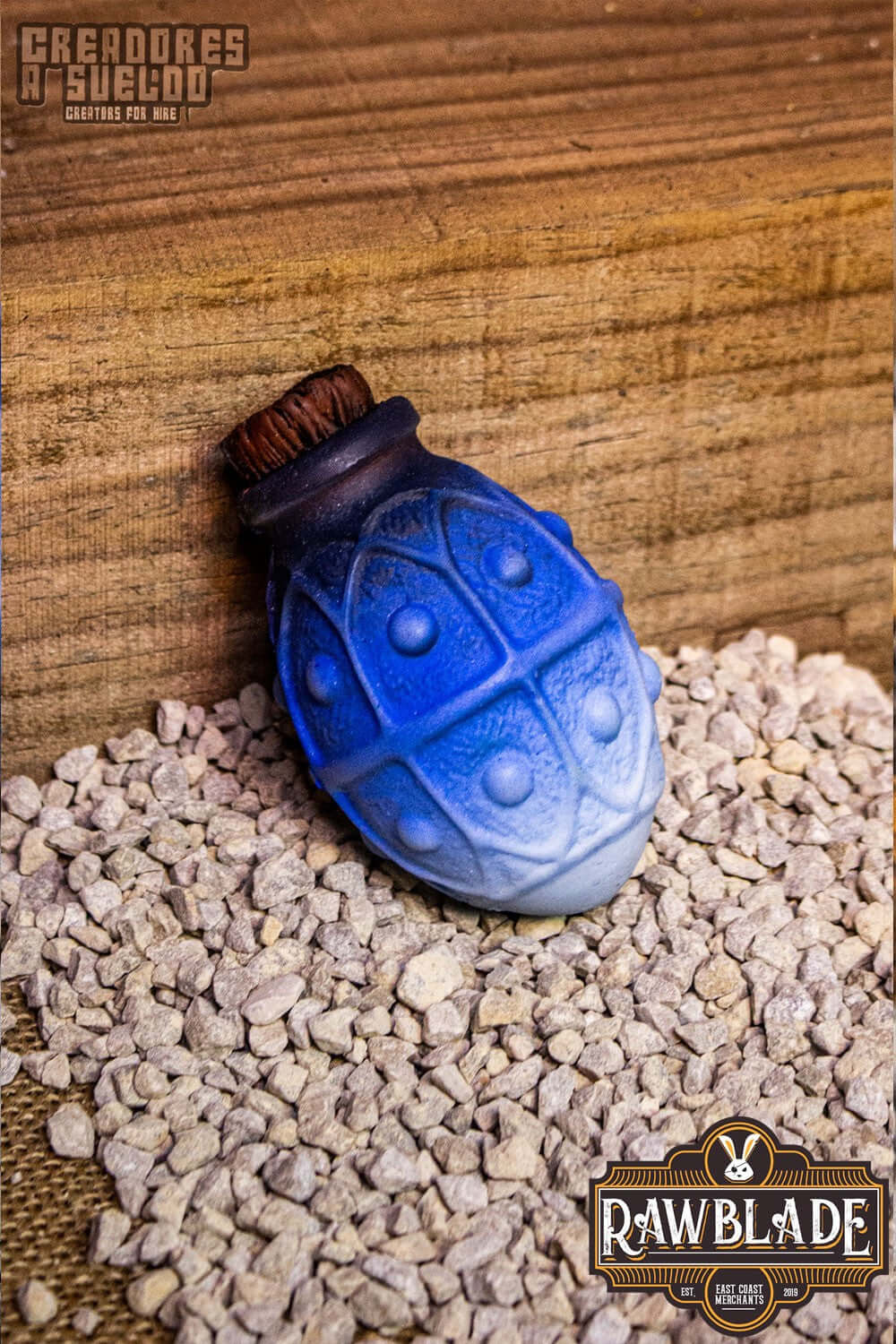 Alchemical Crock in blue color resting on gravel, crafted for alchemists and mages by Rawblade.