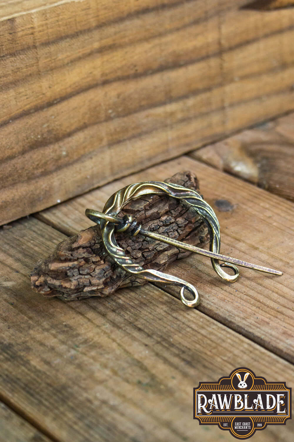 Braided Fibula displayed on rustic wood, showcasing its detailed design for medieval costumes.