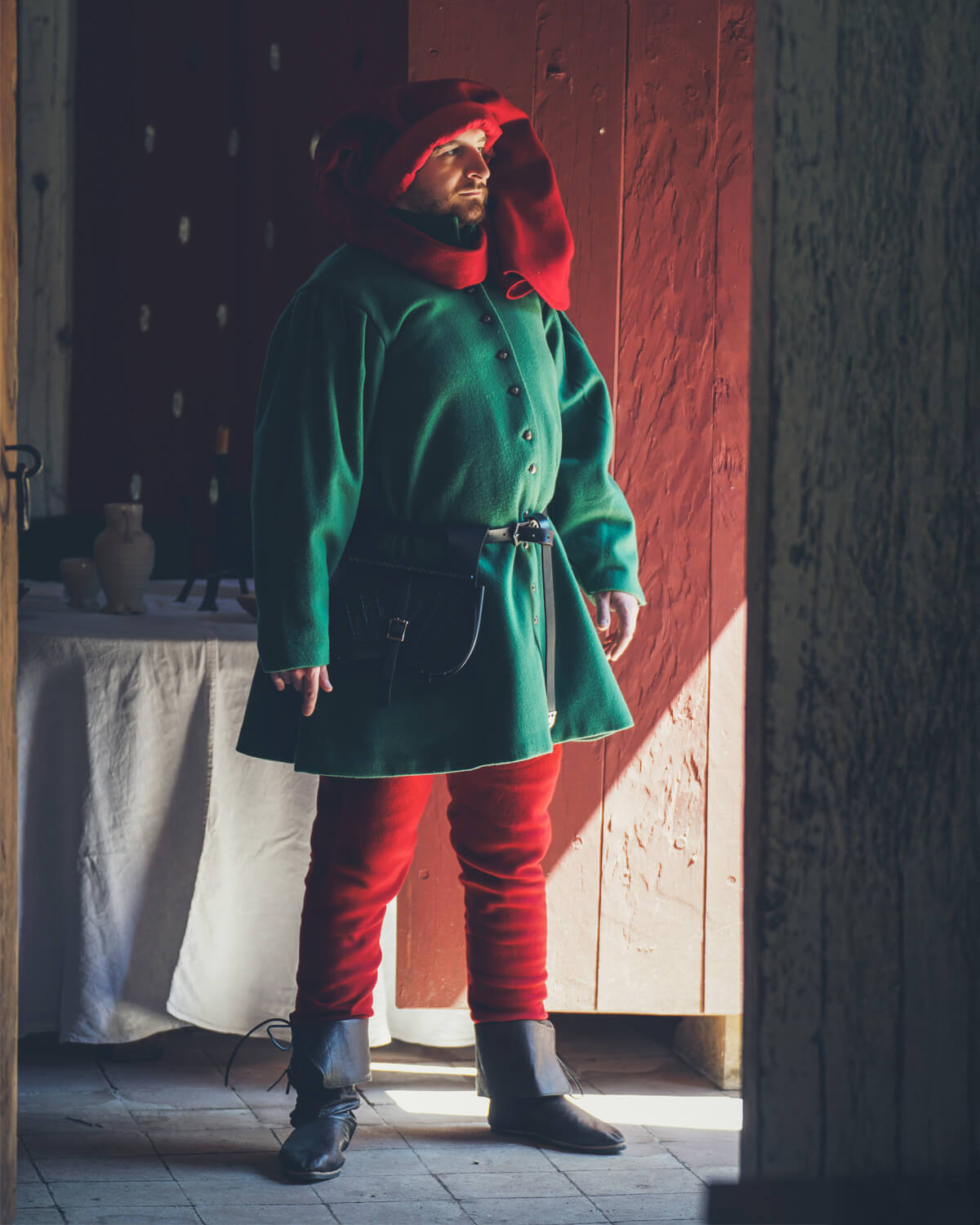Man in green tunic, red hood, and red hose, medieval costume