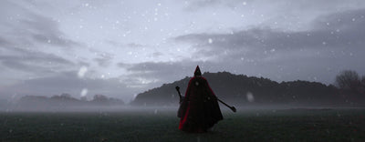 A elf in a deep red cloak walks in a misty open field, facing a dark forested hill. Snowflakes drift across as the sky glows in muted grey tones. The figure holds a long spoon and wooden staff, with a gnome hat on the head. In the full video version, an elf wearing Epic Armoury Illumine armor appears in the same wintry landscape, holding a elven Halbred.